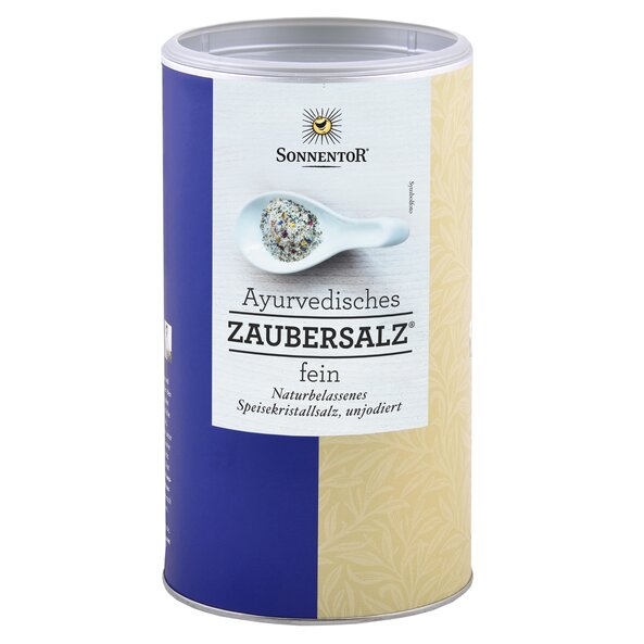 A picture of a big jumbo spice tin Ayurvedic magic salt. On it you can see a white spoon with many spices on it.