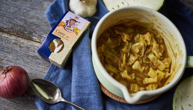 Auf dem Foto sieht man einen Topf Curry mit Kraut. Daneben sieht man eine Packung SONNENTOR Currygewürz. | © SONNENTOR Kraut Curry | © SONNENTOR